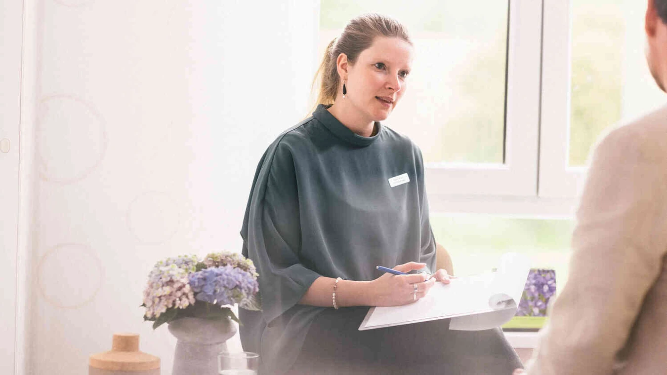 Therapeutin mit notiert im Gespr&auml;ch auf Klemmbrett